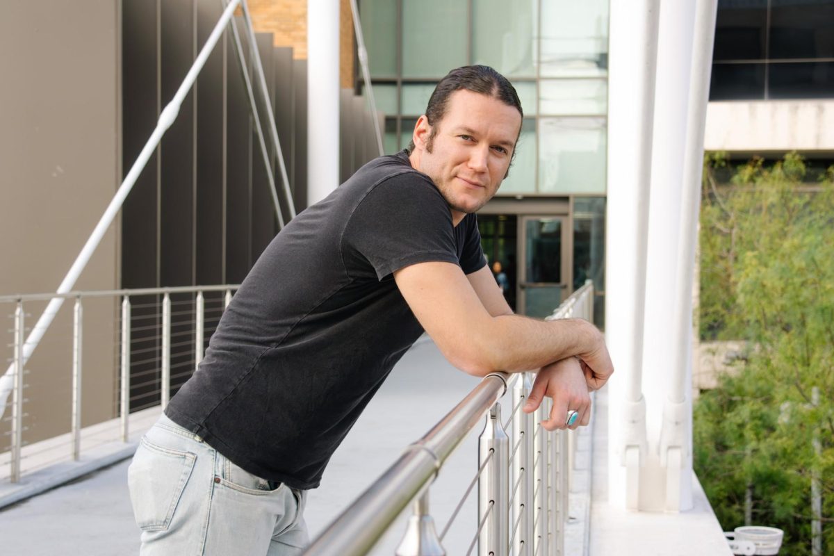 Brady Beal, lead guitarist for Parker McCollum, leans over the Moody pedestrian bridge on Nov. 7, 2024.