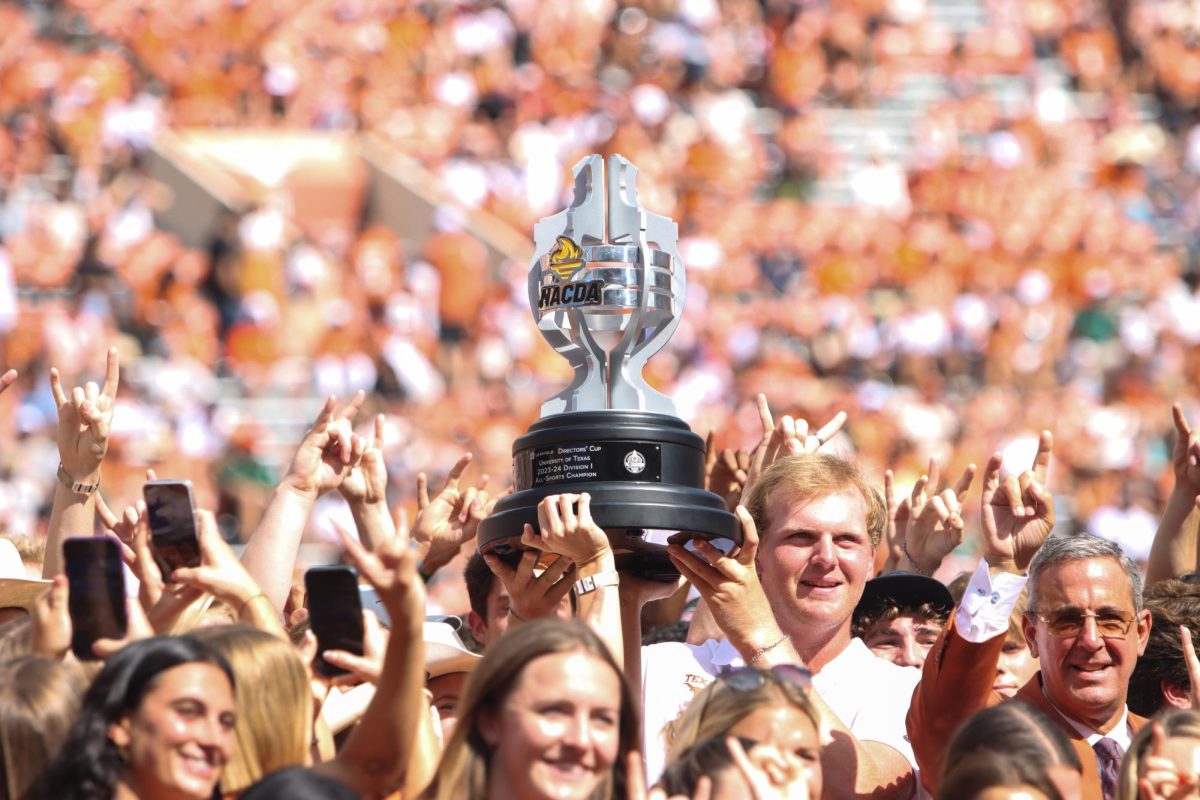 Golfer Tommy Morrison holds up the 2023-2024 Learfield Directors Cup trophy during halftime of the football game against Colorado State on Saturday.