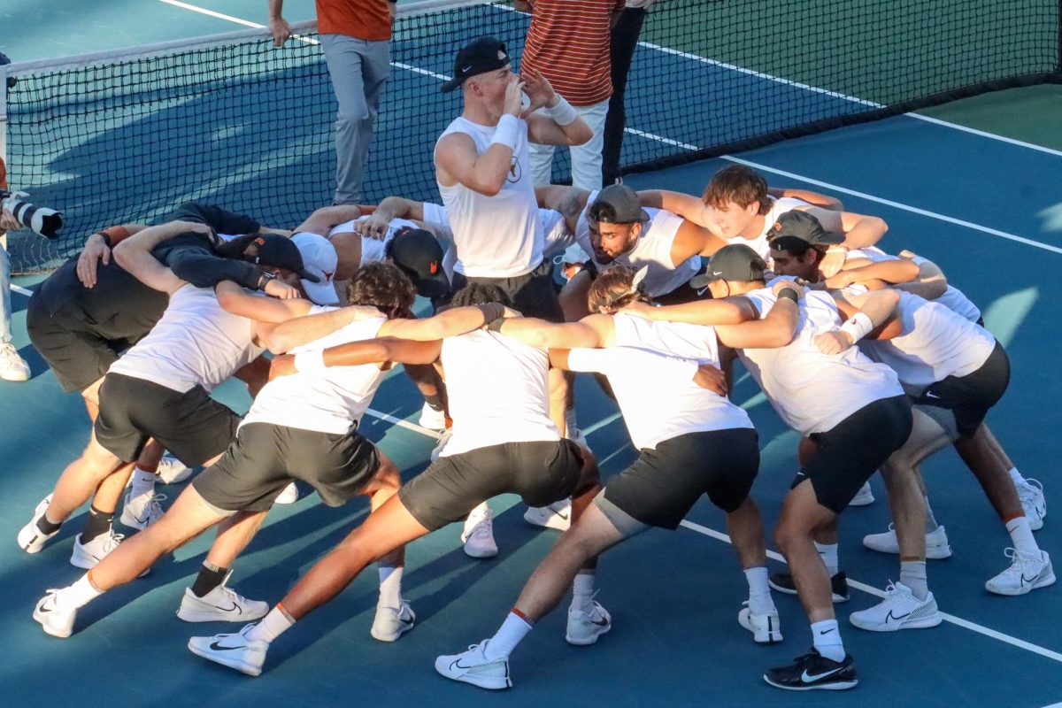 The Texas men's tennis team chants before the match against Virginia begins on Jan. 18, 2024.