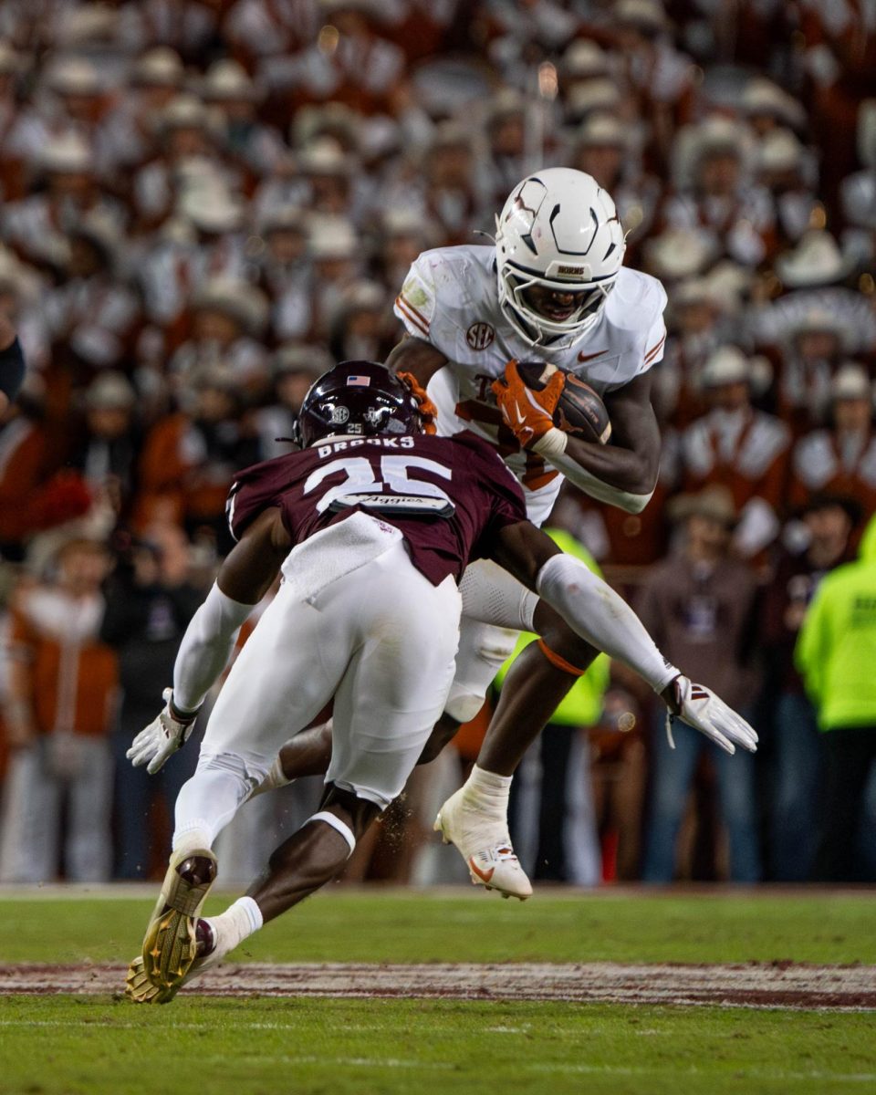 Running back Quintrevion Wisner jumps around A&M defensive back Dalton Brooks during the Lone Star Showdown on Nov. 30, 2024. 