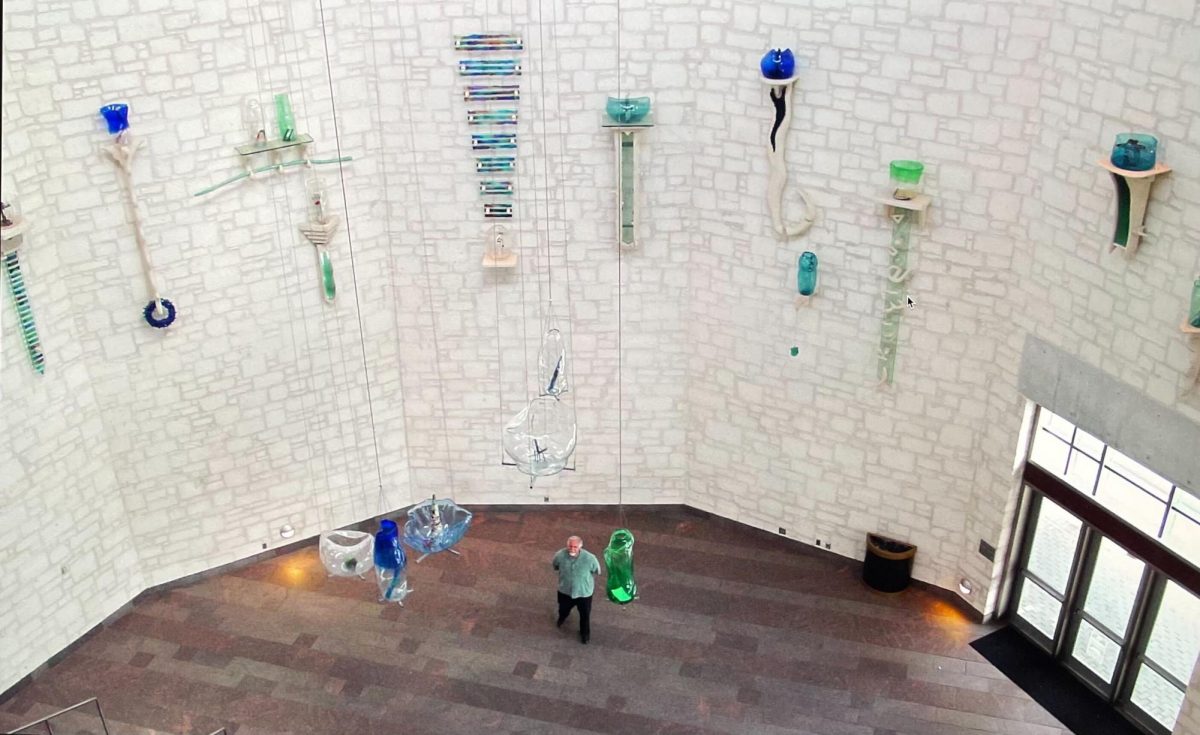 Damian Priour with Waller Creek shelves in Austin Convention Center rotunda.