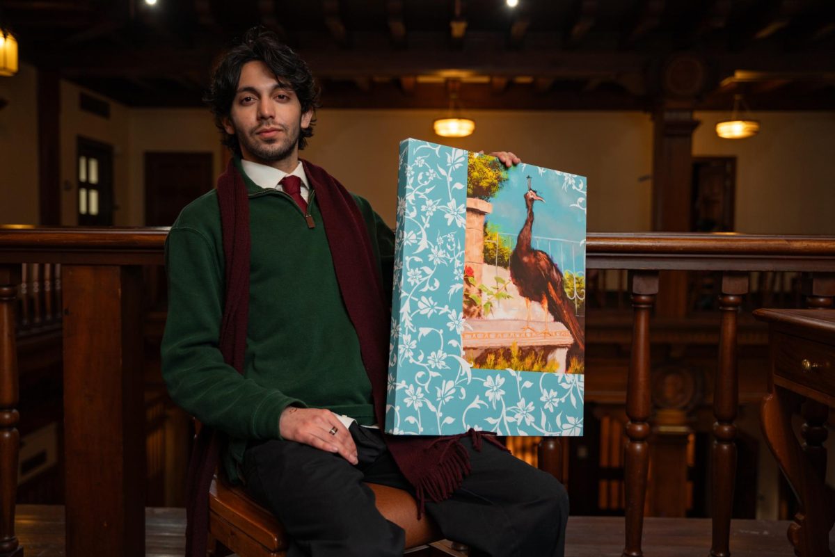 Religious studies junior Hasan Ansari stands for a portrait with his art in the Texas Union building on Feb. 17, 2025. Ansari was an organizer for the Texas Muslim Students' Association Art Festival.