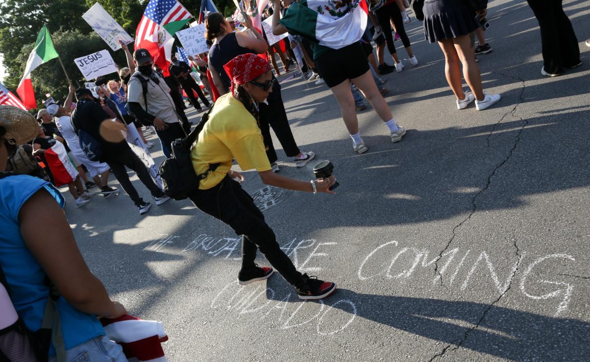 A protester waves sage above chalk at the No Kings protest in front of the Texas Capitol on June 14, 2025. 