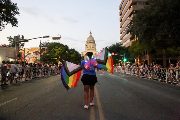 A participant of the 2025 Austin Pride Parade walks in front of the Texas Capitol on Aug. 23, 2025.