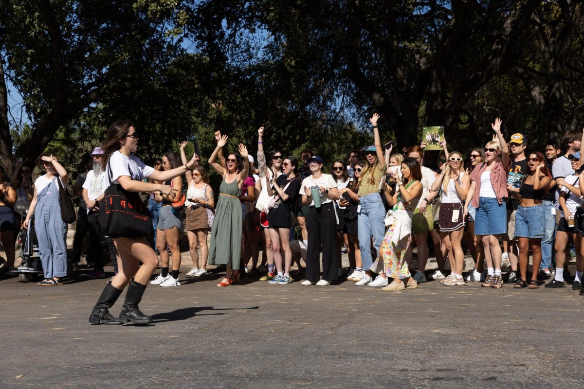 Fans cheer as a HAIM representative hypes up the crowd for social media on Sept. 26, 2025. More than 100 people arrived to the downtown cul-de-sac to meet HAIM. 