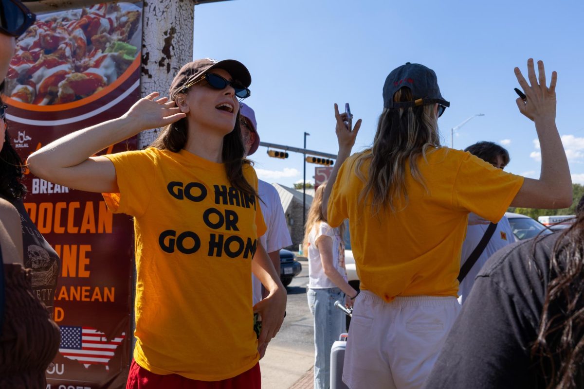 Danielle and Este Haim sing while waiting at a stoplight on their walk on Sept. 26, 2025. They led the crowd to Jo's Coffee on South Congress. 