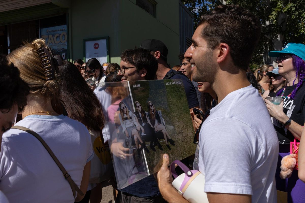 A fan holds his recently signed HAIM record outside Jo's Coffee on Sept. 26, 2025. The three sisters thanked the fans for going on the walk before departing. 