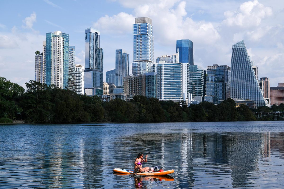 A paddle boarder journeys across Lady Bird Lake on Oct. 23. The Austin skyline and Lady Bird Lake can be scenically taken in from Lou Neff Point on Ann and Roy Butler Trail in Zilker Metropolitan Park.  
