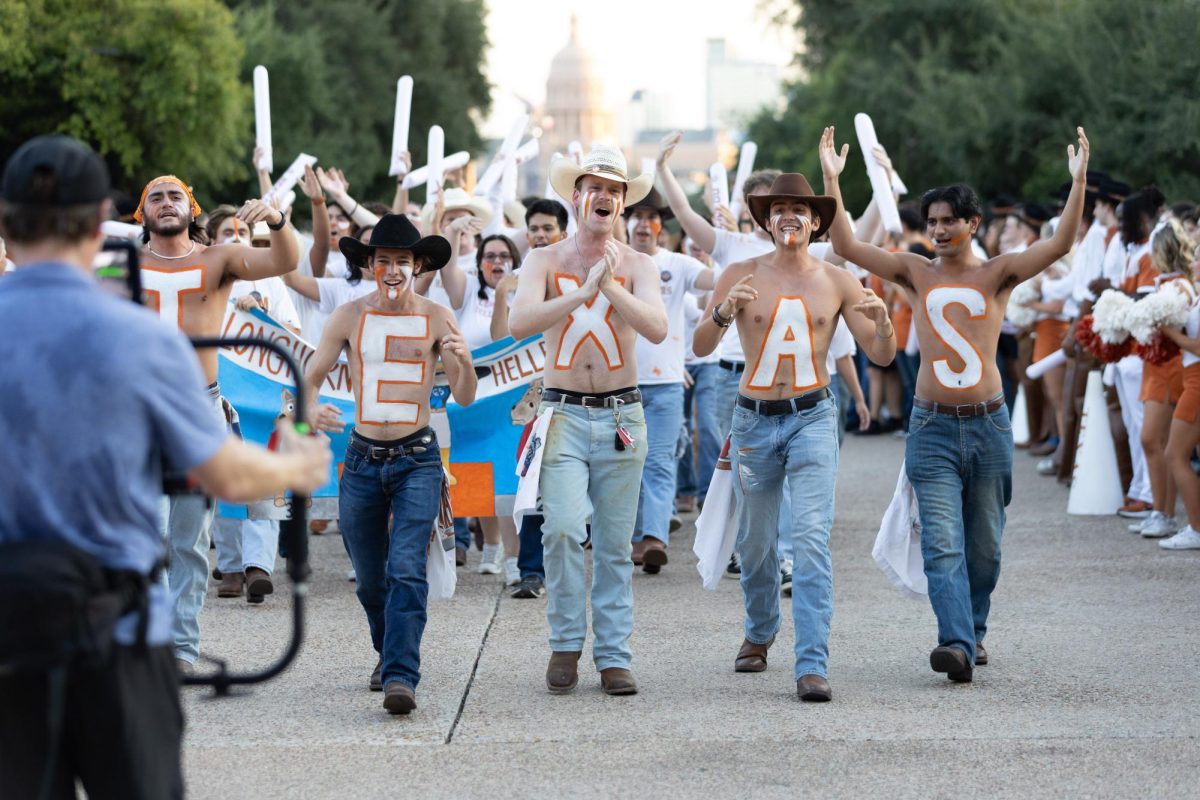 The Longhorn Hellraisers walk towards the tower for the Texas Fight Rally on Oct. 8.