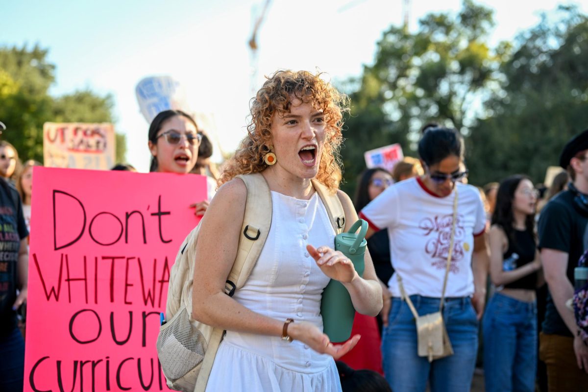 Humanities honors senior Kira Small chants with the rest of the crowd in objection of the compact proposed by President Donald Trump as the group makes a stop in front of the Tower during the protest organized by SDS on Oct. 20.