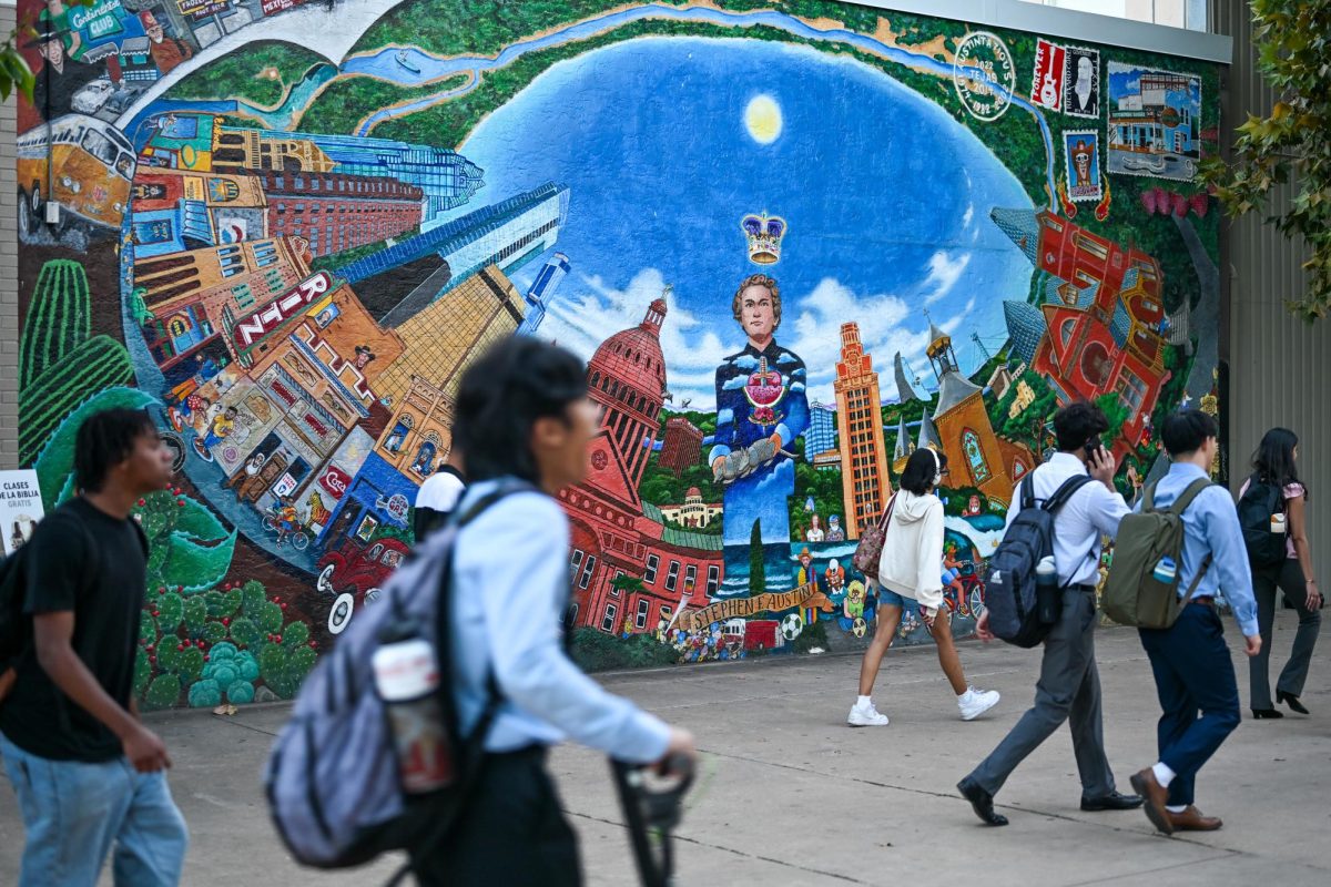Students walk past the 1974 mural "Austintatious" located on the side of the Co-op along The Drag on Nov. 5.