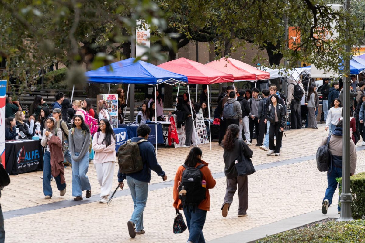 Students walk past tables lining Speedway as organizations pitch their clubs to students on Jan. 13, 2026.