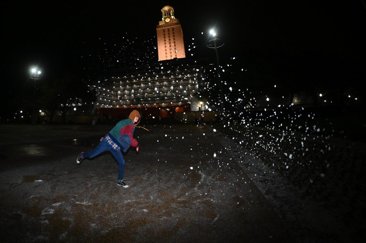A UT student throws a snowball in front of the UT Tower on Jan. 25.