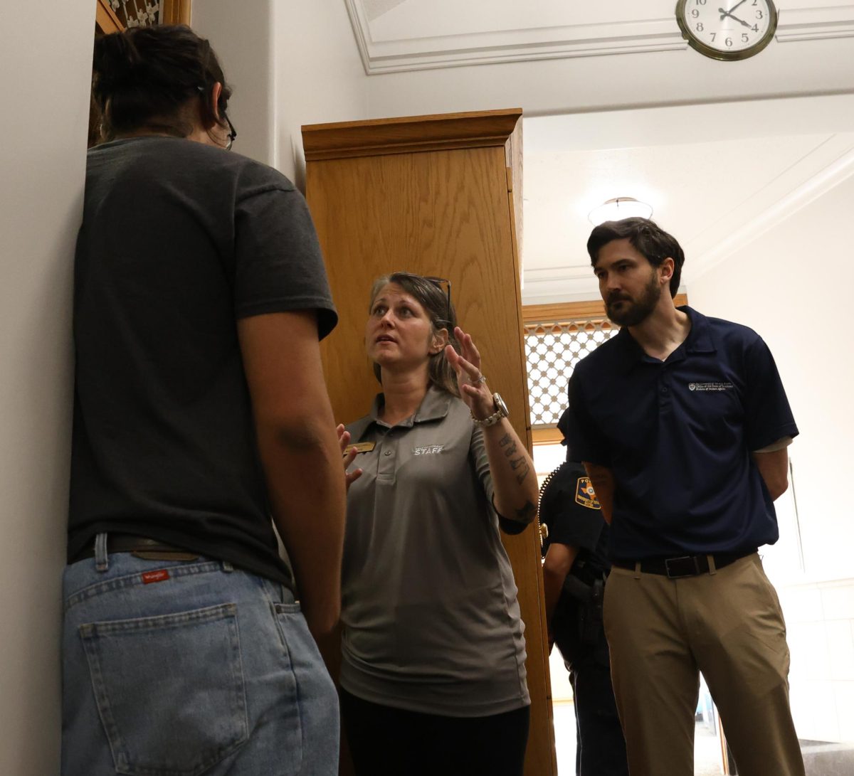 Kelly Soucy and Aaron Voyles, associate deans of students, tell computer science second-year Daniel Ramirez that the 14 students engaging in a sit-in in the executive vice president and provost's office Nov. 7, 2025 need to leave to tower immediately. Ramirez said the group was trying to push for a meeting with senior leadership at UT, including Provost William Inboden.