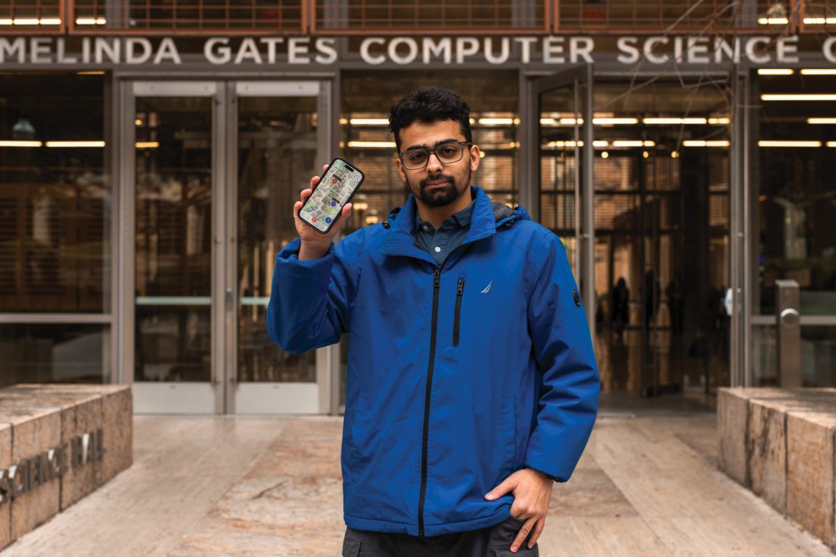 Mohammad Rashid, a first-year computer science major, poses with the Merch phone application in front of the Gates Dell Complex on Tuesday. Rashid developed the Merch app. 