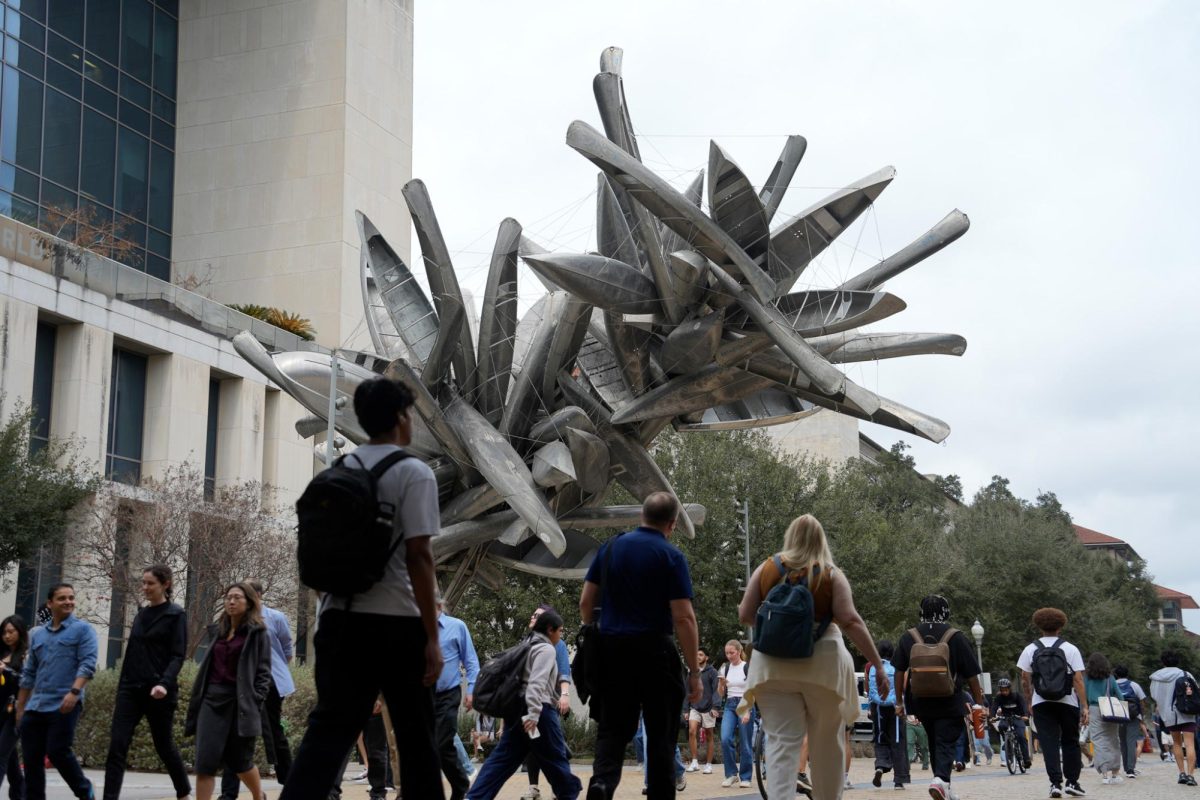 People at walk under Nancy Rubins' sculpture "Monochrome for Austin" (2015) next to the Norman Hackerman Building at UT Austin on Feb. 10, 2026. As a part of the College of Fine Art's Landmarks program, the sculpture has become a frequent desination for campus tours.