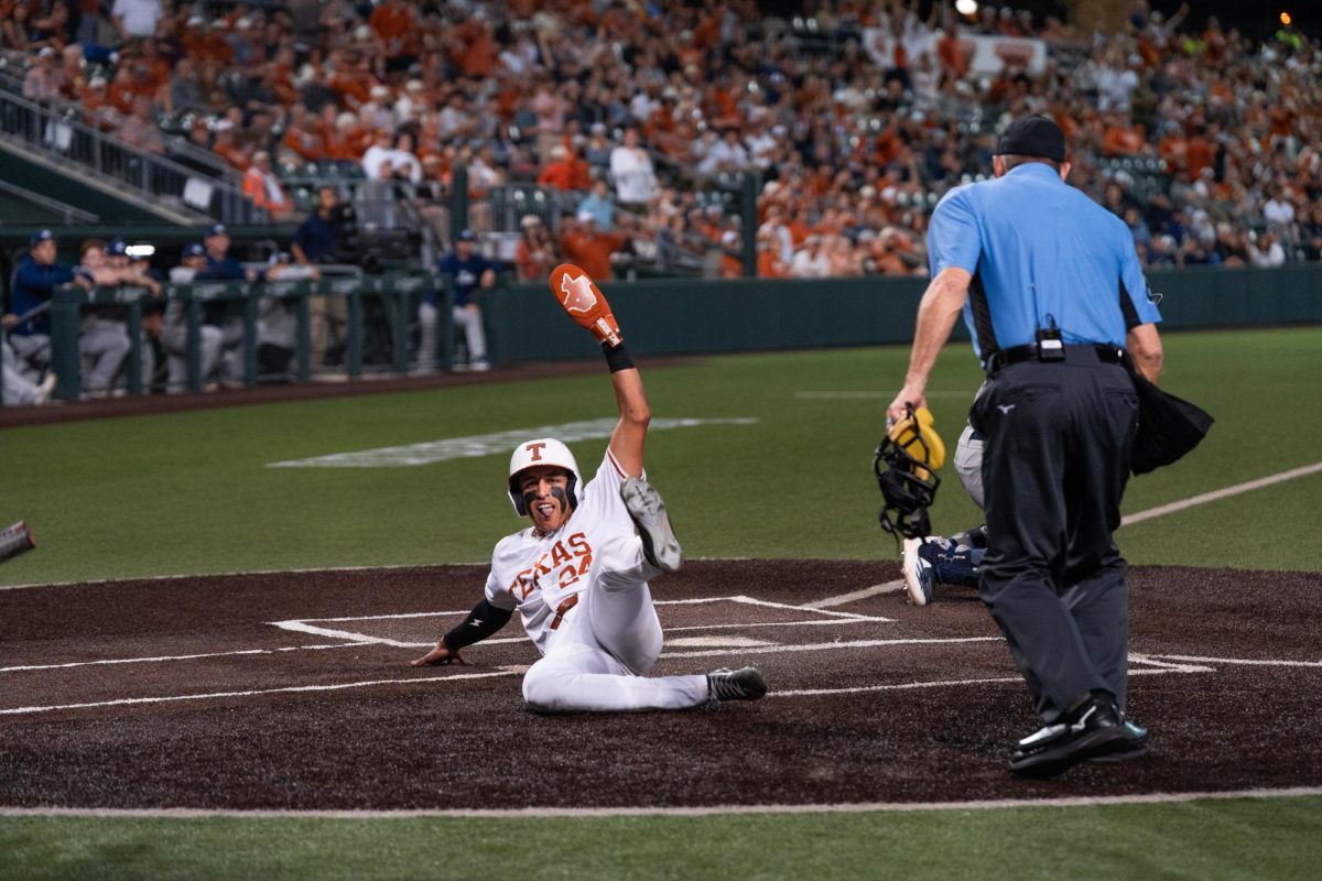 Sophomore Adrian Rodriguez slides at home plate at the Texas baseball game against the UC Davis Aggies at UFCU Disch-Falk Field on Feb. 13. 