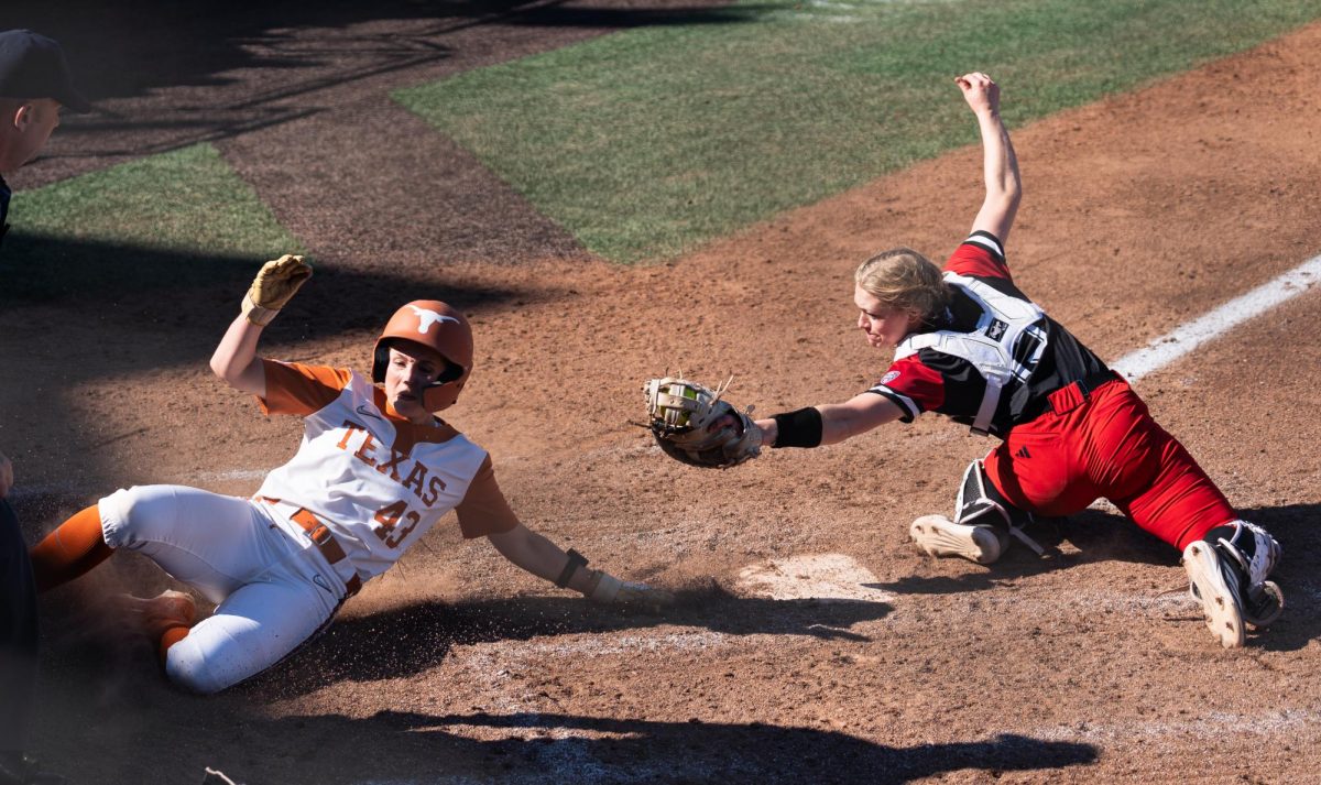 Senior infielder Leighann Goode slides into home base at Texas' game against Northern Illinois University on Sunday, Feb. 15.