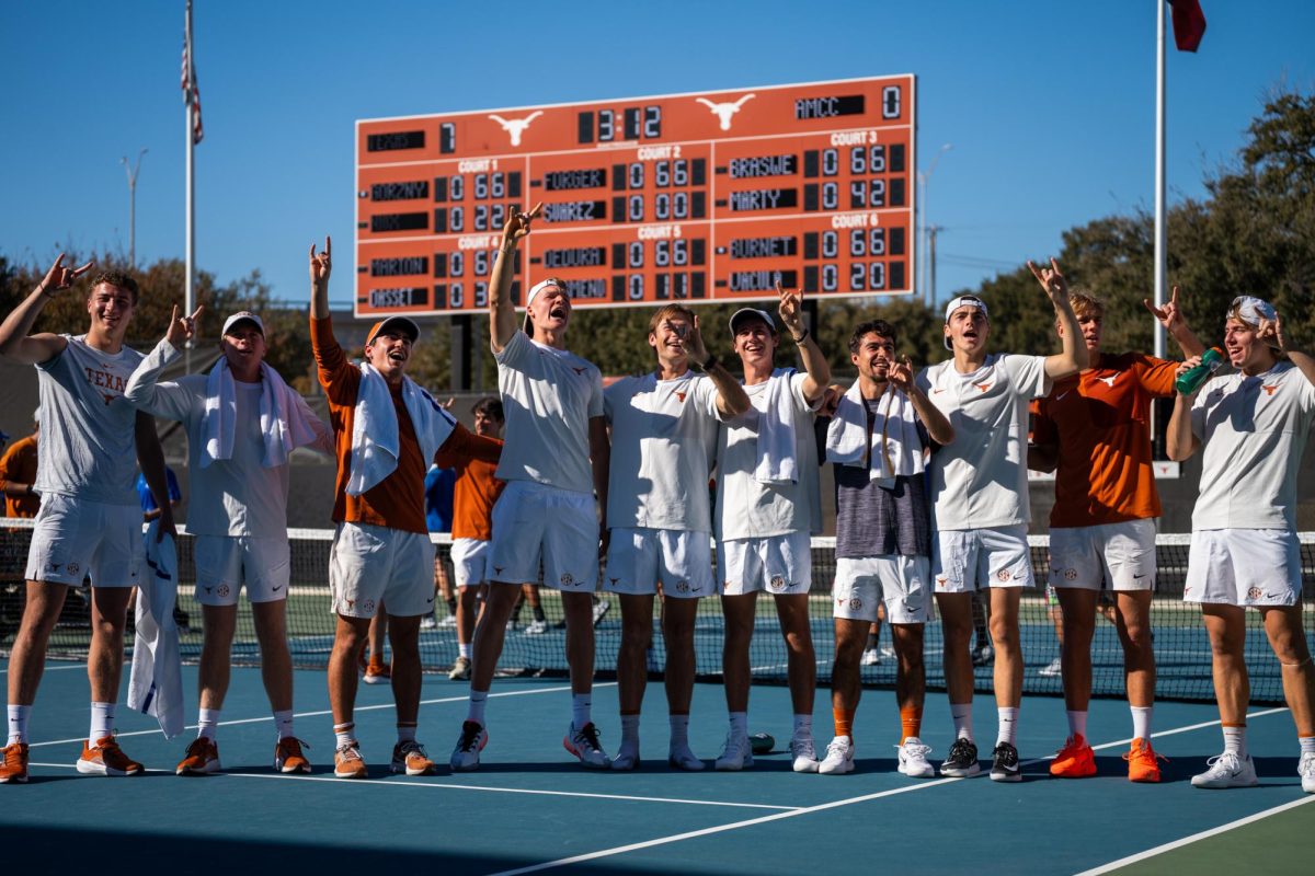 The Texas men's tennis team sings along to "The Eyes of Texas" after a  match against Texas A&M-Corpus Christi on Feb. 7.