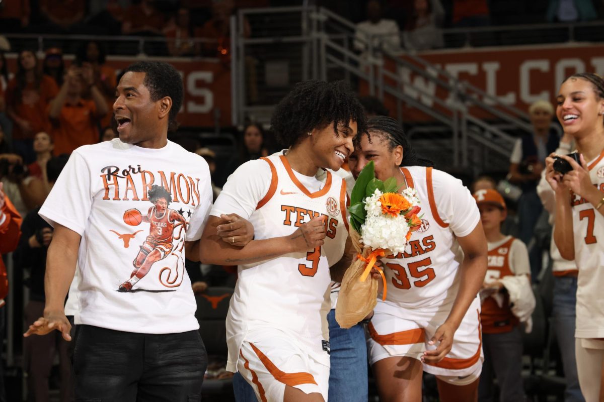 Graduate guard Rori Harmon laughs at a comment from junior forward Madison Booker as she walks out during Texas' senior recognition ceremony following their game against Mississippi State at the Moody Center Feb. 22.