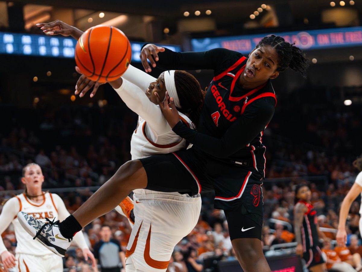 Georgia redshirt sophomore Miyah Verse hits the ball out of senior center Kyla Oldacre's hands during Texas' game against Georgia at Moody Center on Feb. 26.