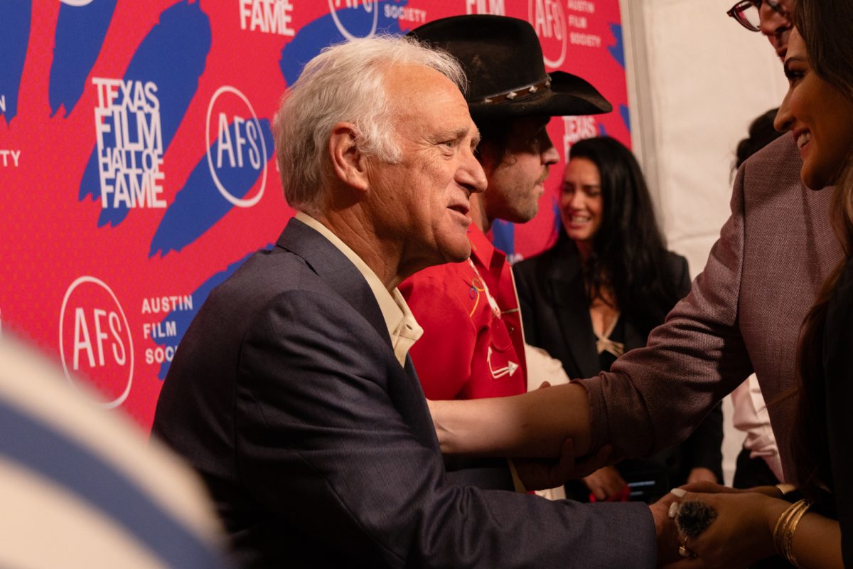 Austin Mayor Kirk Watson shakes someone's hand on the red carpet of the 2026 Texas Film Awards on March 5.
