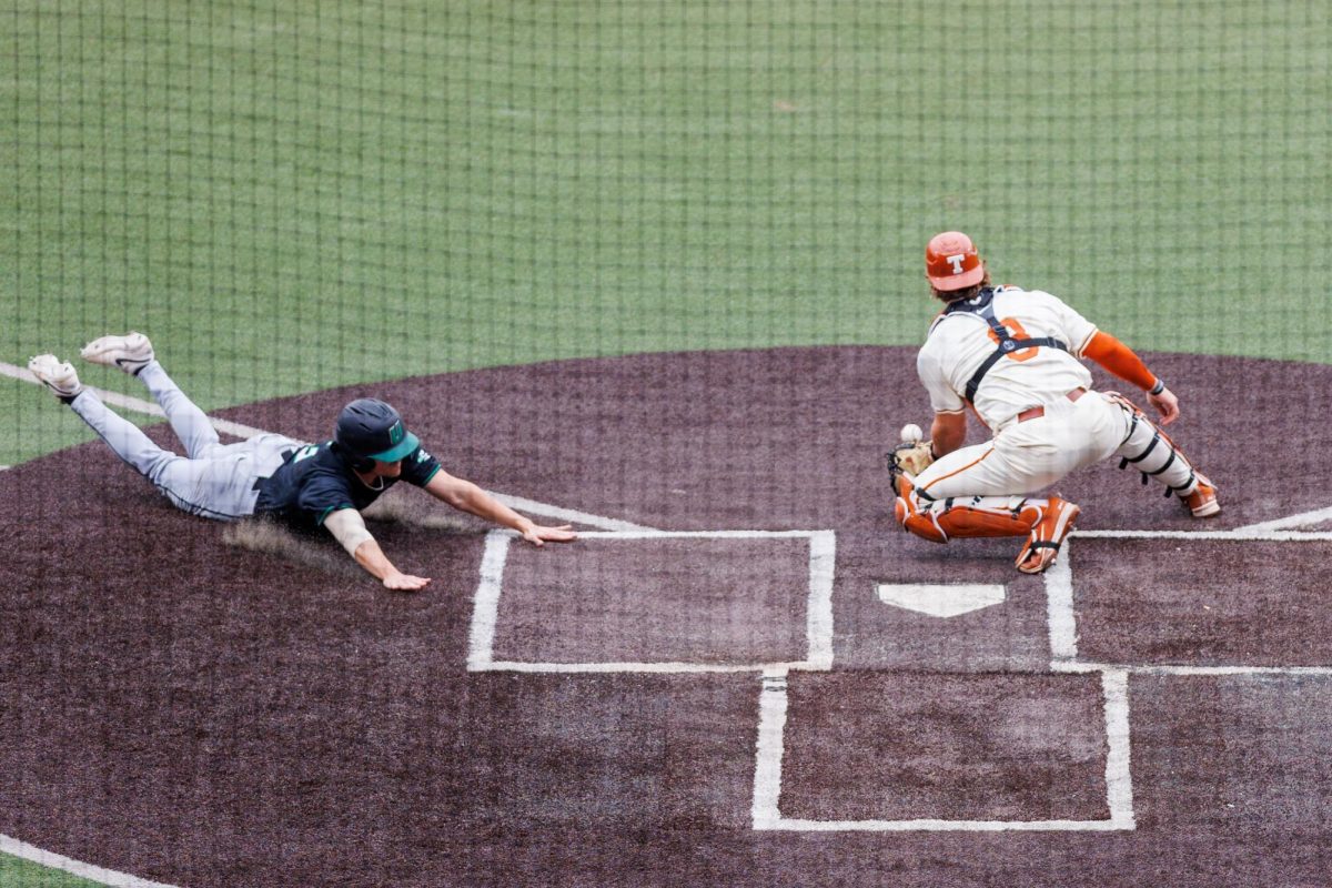 Junior catcher Carson Tinney catches the ball as USC Upstate senior infielder Jake Armset slides to home at Texas' game at Disch-Falk Field on March 8.