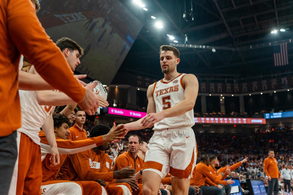 Junior forward Camden Heide high-fives his teammates after getting subbed out in a game against Florida at the Moody Center on Feb. 25.