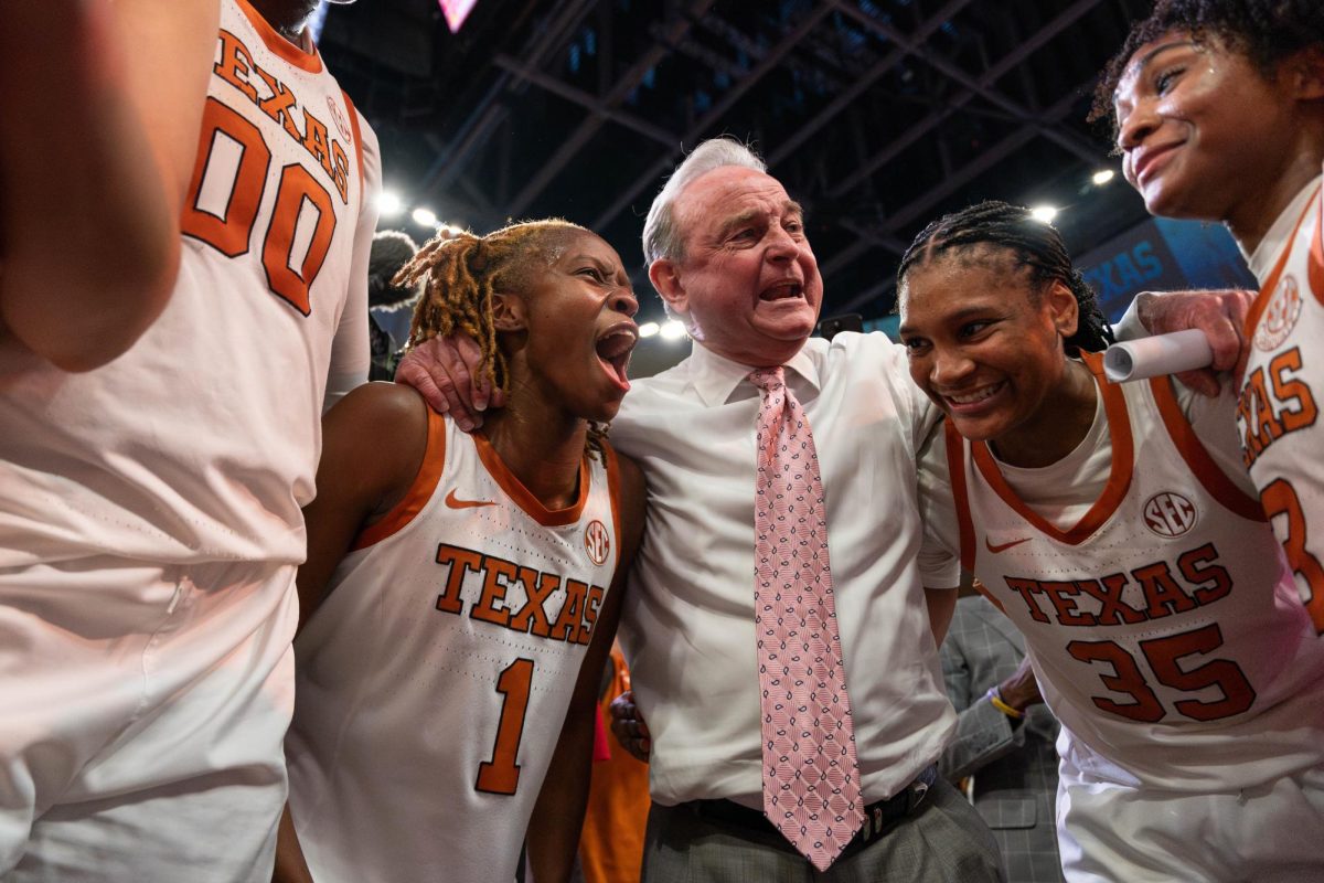 Head coach ‎Vic Schaefer smiles in the huddle with players Bryanna Preston (left) and Madison Booker (right) after Texas’ win against LSU on Feb. 16, 2025.