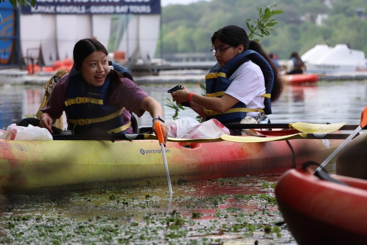 A volunteer group picks up trash near the dock of Austin Rowing Club on Saturday, April 11.