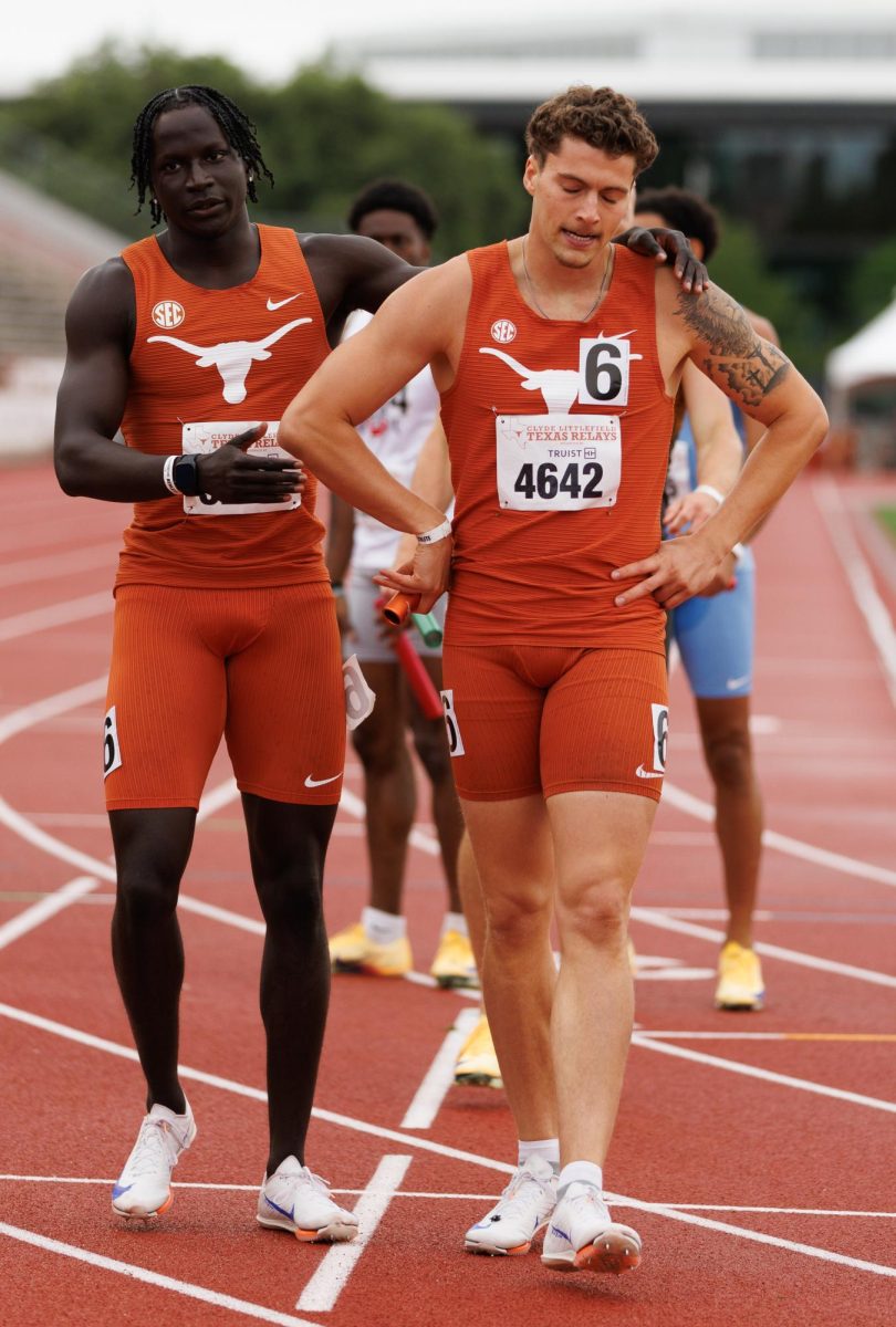 Texas freshman Waly Bathily, left, consoles senior Logan Popelka after placing third in the men’s 4x400m relay on April 4.
