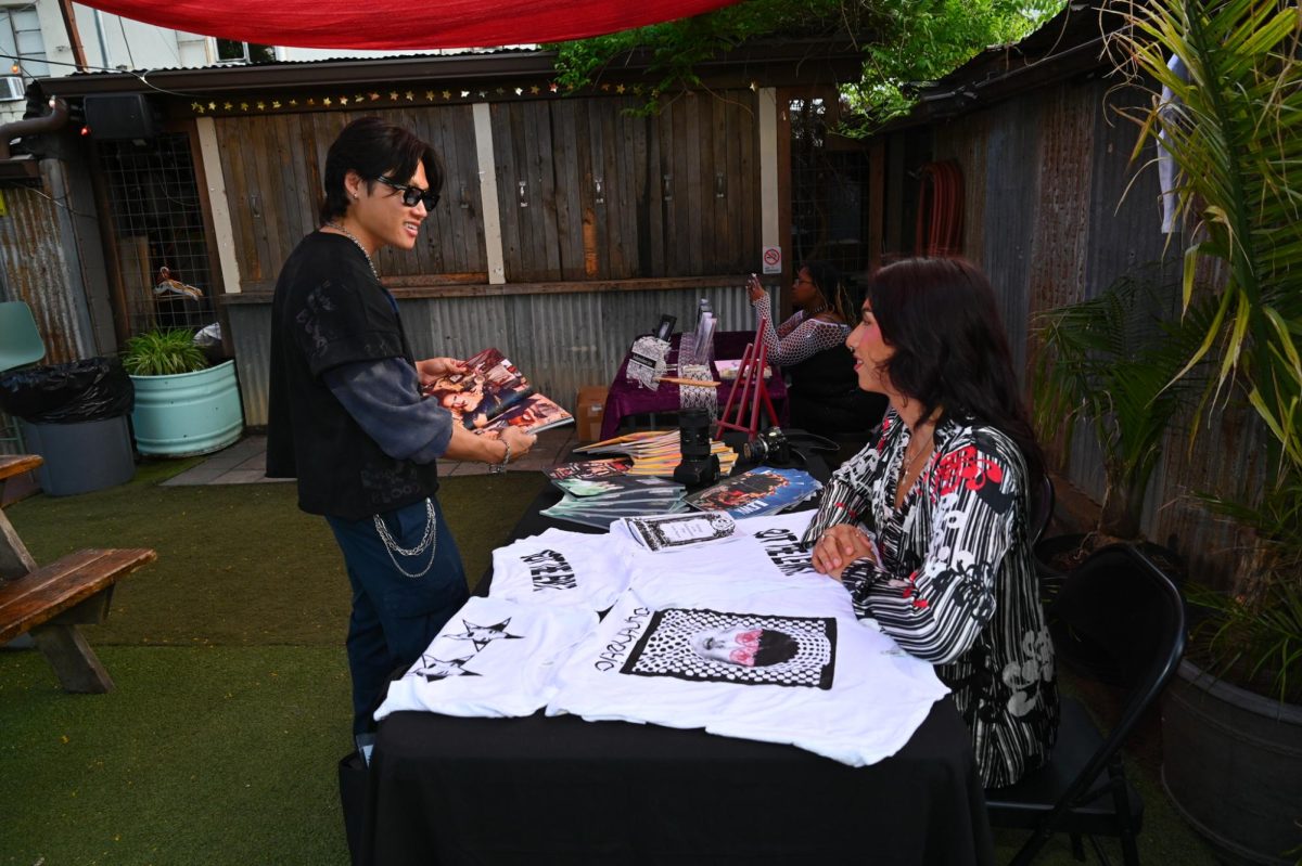 Zine Fest attendee views Lewk Magazine's booth at Eulogy of the Independent Zine on the patio of Hotel Vegas on Saturday, April 11.
