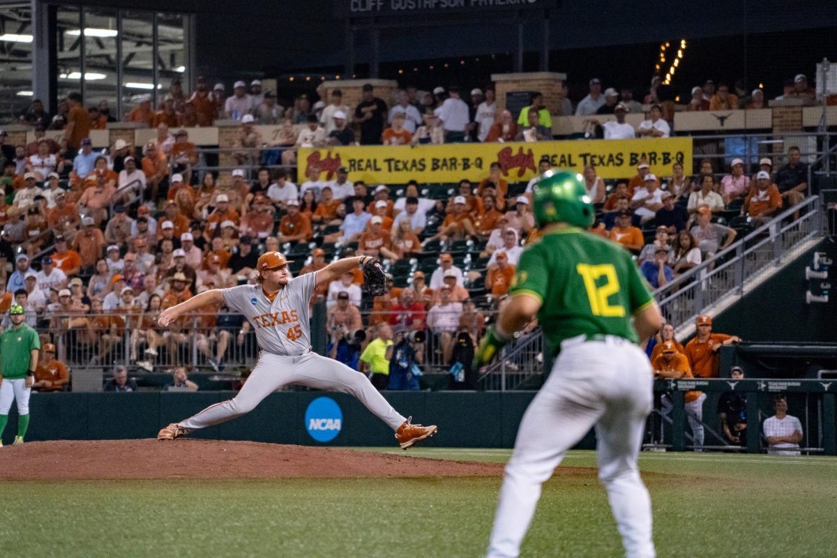 Junior pitcher Thomas Burns throws a pitch as Oregon infielder Ryan Cooney leads off his base during Game 2 of the Austin Super Regional against Oregon on Sunday, June 7 at UFCU Disch-Falk Field.