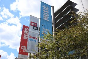 The banners fly outside of the KUT building at the University of Texas on Sept. 22, 2025. They showcase their multiple news, radio and music stations that are available to Austin residents.