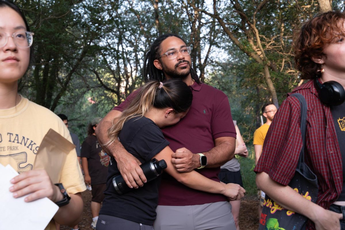 Two Austinites pictured embracing in the crowd during the "An Evening for Malin" memorial in Pease Park on Wednesday, June 24.