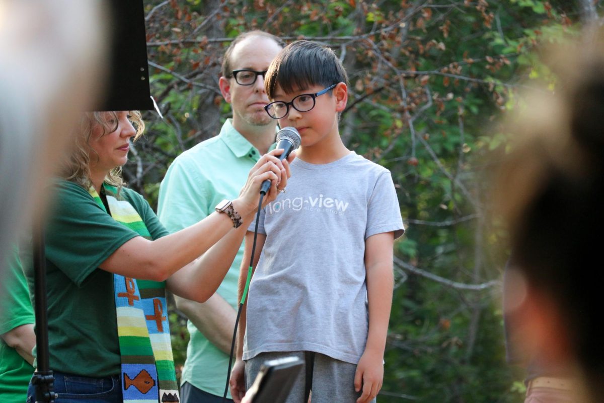 An Austin elementary school student takes the stage to read an original poem commemorating Malin at her memorial service in Pease Park on Wednesday, June 24.