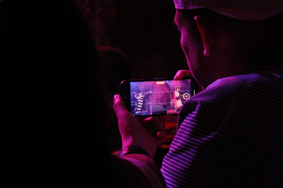A fan records Late Wife's performance at Emo's Austin during NPR's The Tiny Desk Concert On The Road tour on Wednesday, June 24.