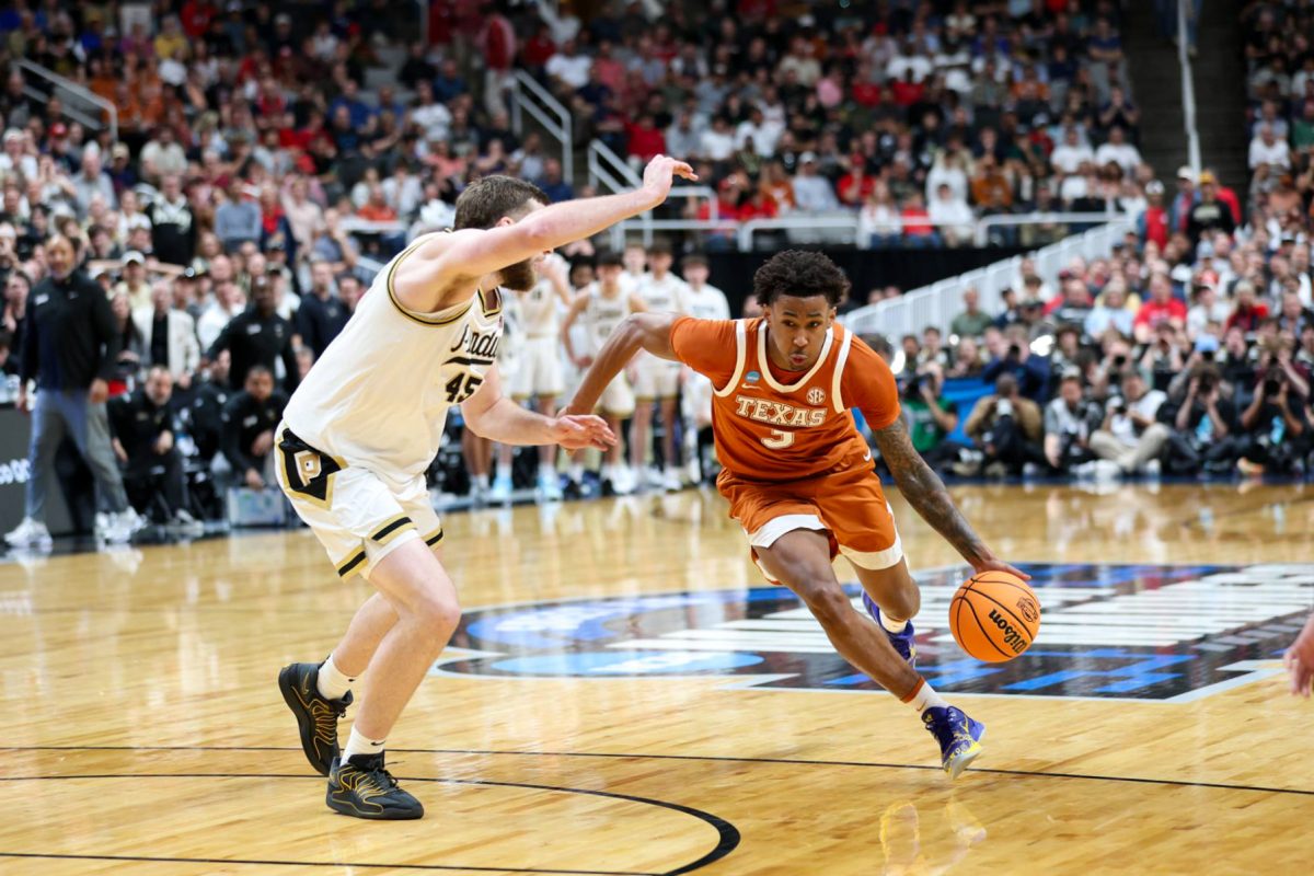 Guard Dailyn Swain dribbles the ball against center Oscar Cluff the Texas vs. Purdue Sweet 16 game at the SAP Center in San Jose, California, on March 26. 