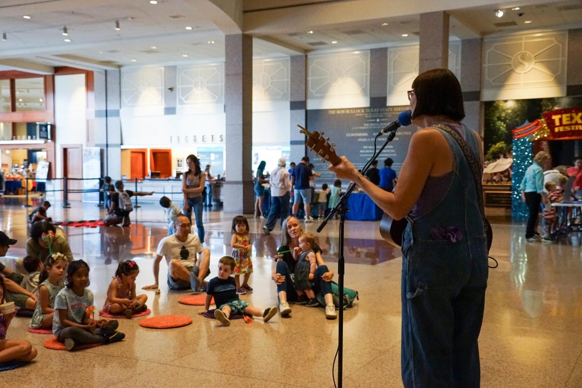 Staci Gray performs children's songs on her guitar as children and parents sing along in the Grand Lobby during the Bob Bullock Birthday Bash at the Bob Bullock Museum in Austin, Texas, on Sunday, July 12.